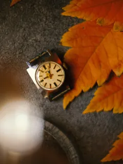 Malé hodiny na stole vedle listu