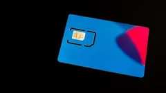 Modrá SIM karta s čipem na černém pozadí pro mobilní technologie