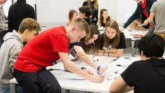 Studenti spolupracují u stolu ve třídě během skupinové práce.